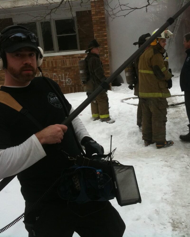 Sound operator with a boom mic on a fire scene shoot, behind the scenes of Mind Shift documentary production