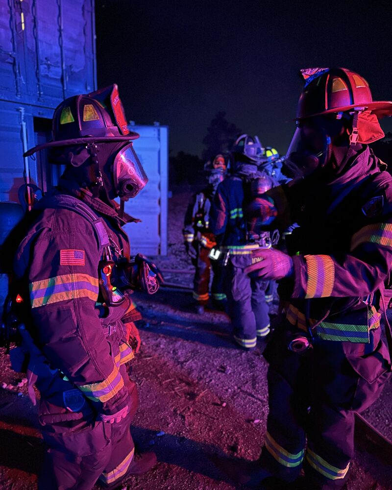 Cinematographer filming firefighters at a car fire, behind the scenes of Mind Shift documentary production