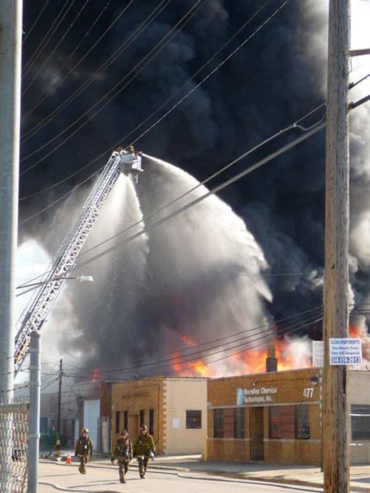Firefighters spraying water on a large industrial fire during BURN X